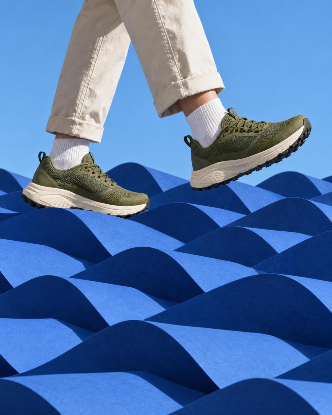 Stop motion product effect with a running shoe stepping over cobalt paper waves